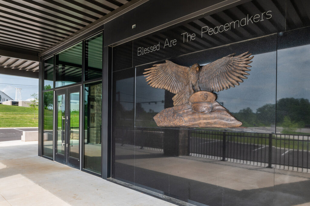 Exterior view of the Cookeville Police Department Headquarters, featuring artwork of an eagle protecting a police officer hat and a quote saying "Blessed are the peacemakers".